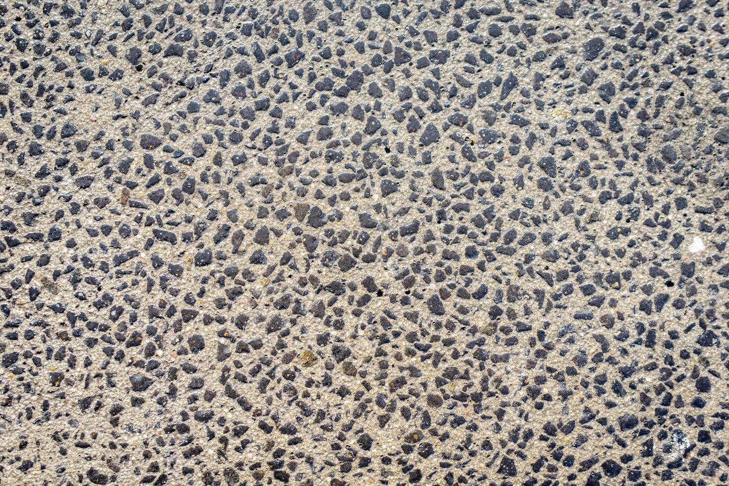 gray plaster on the wall with fine black pebbles photo