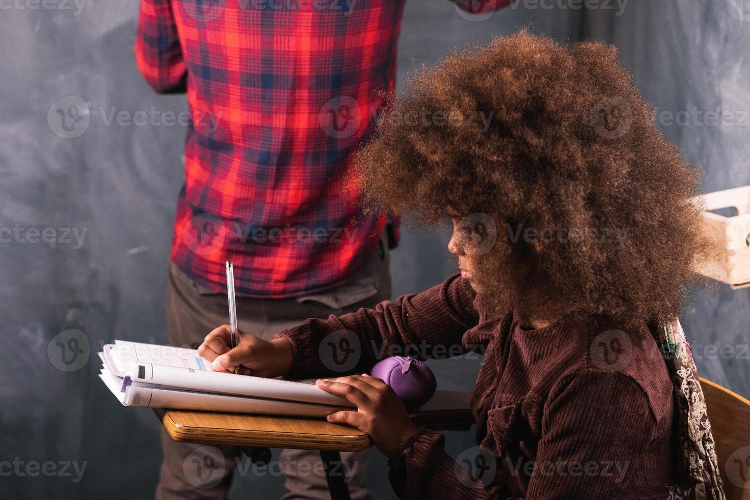 Multiracial teacher and pupil in classroom at math lesson photo