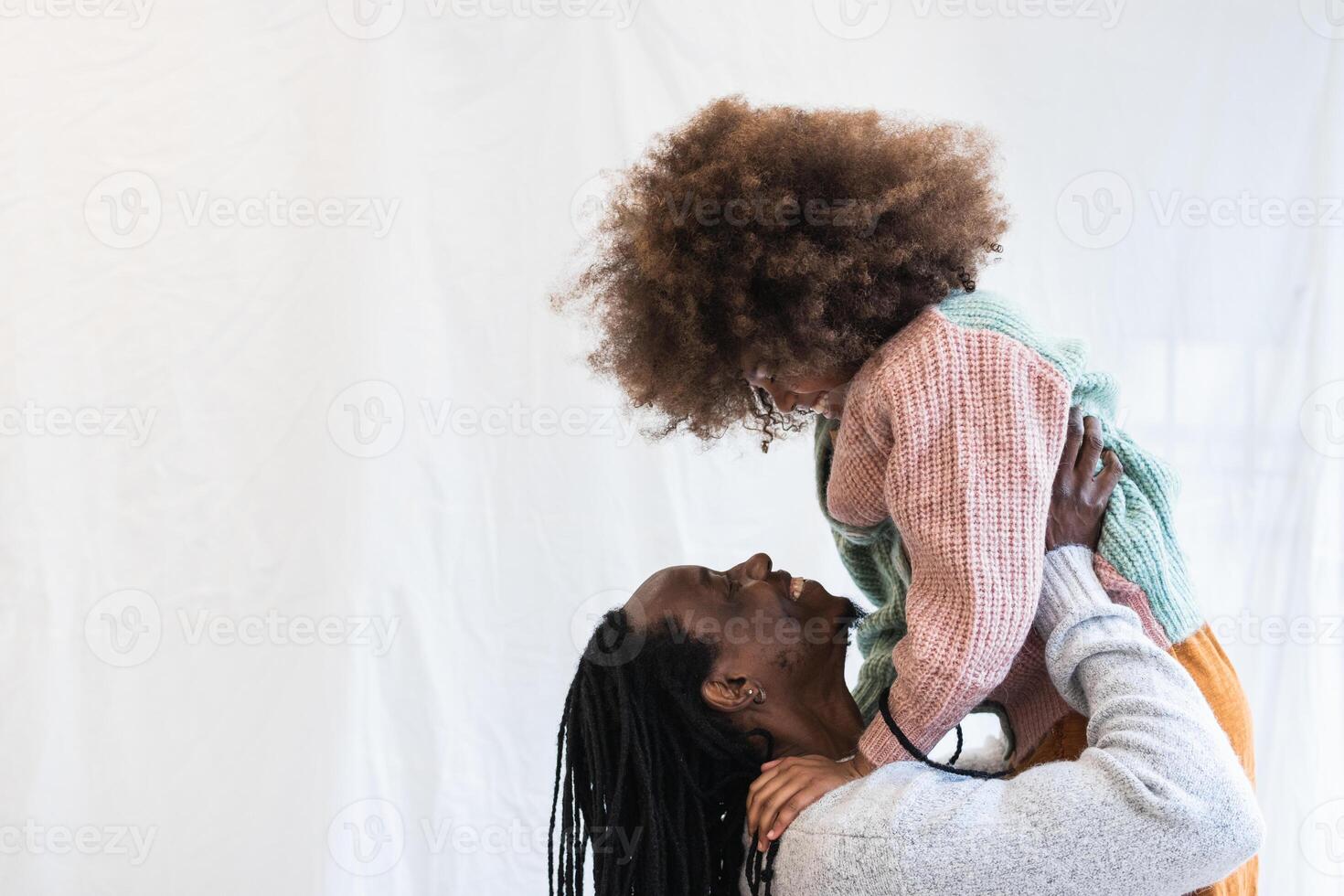 Black man carrying daughter on hands photo
