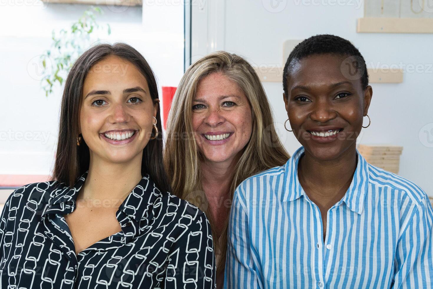 Cheerful diverse coworking women looking at camera photo