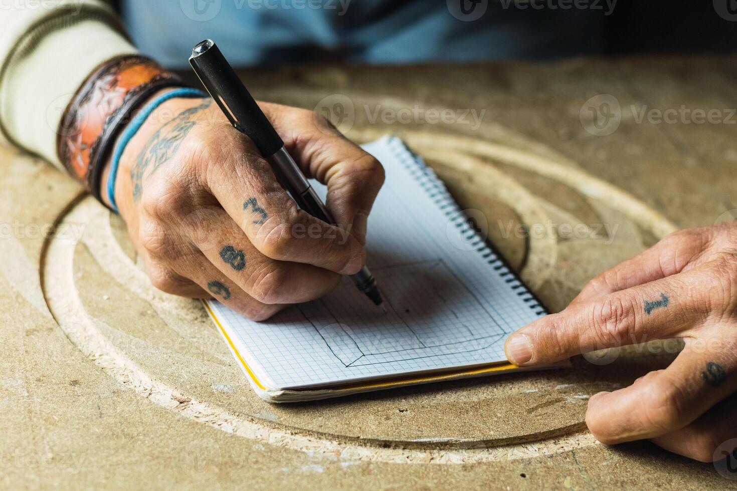 Crop woodworker drawing sketch in notebook photo