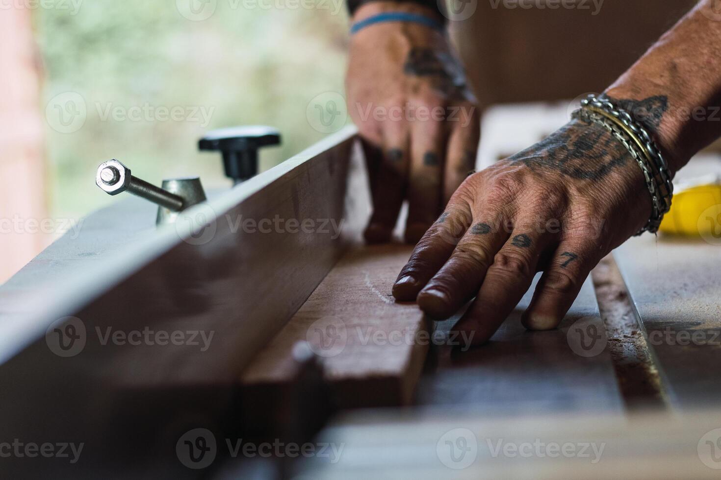 Crop male carpenter cutting wood with circular saw photo