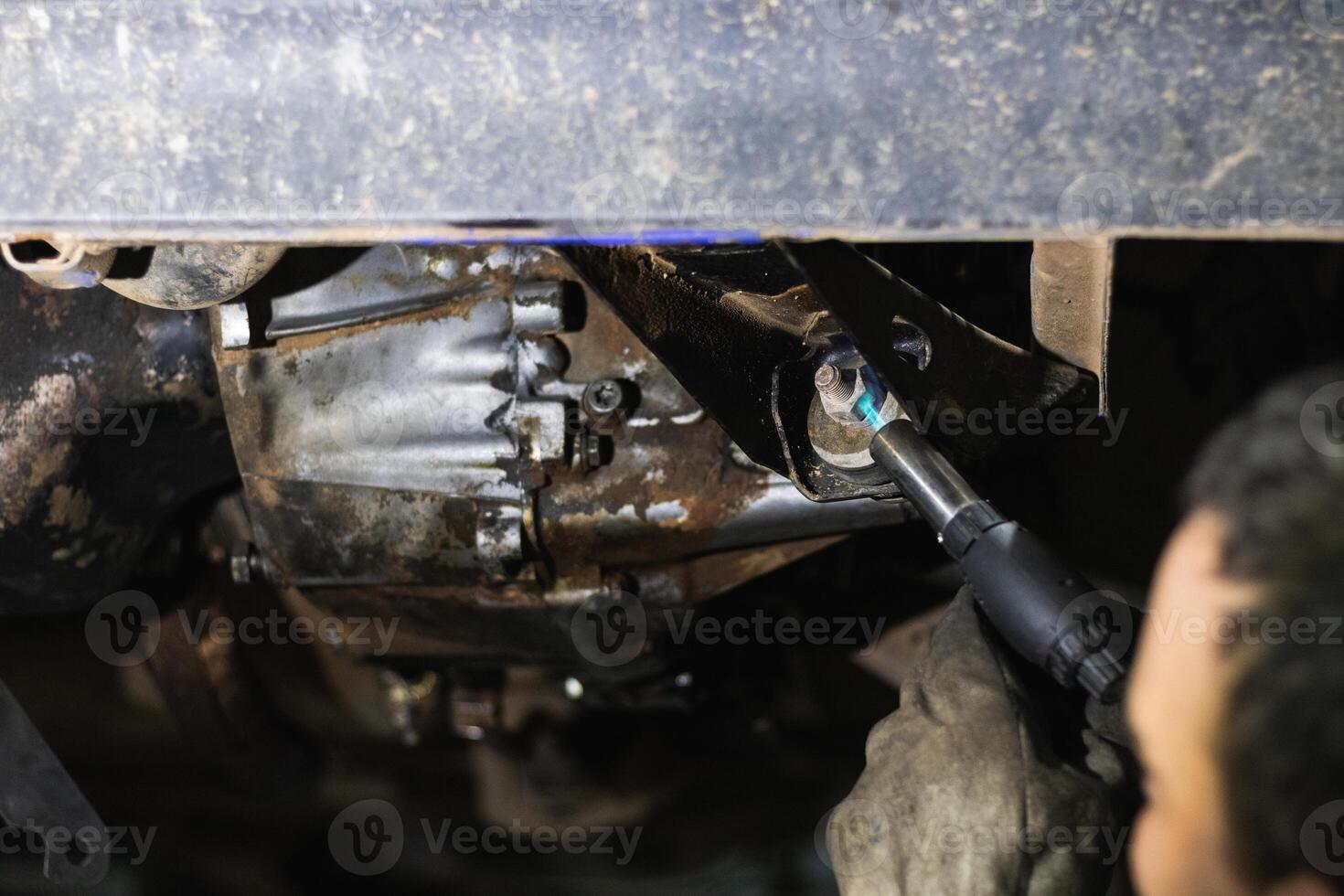 Anonymous repairman removing car details with torch during work in auto service photo