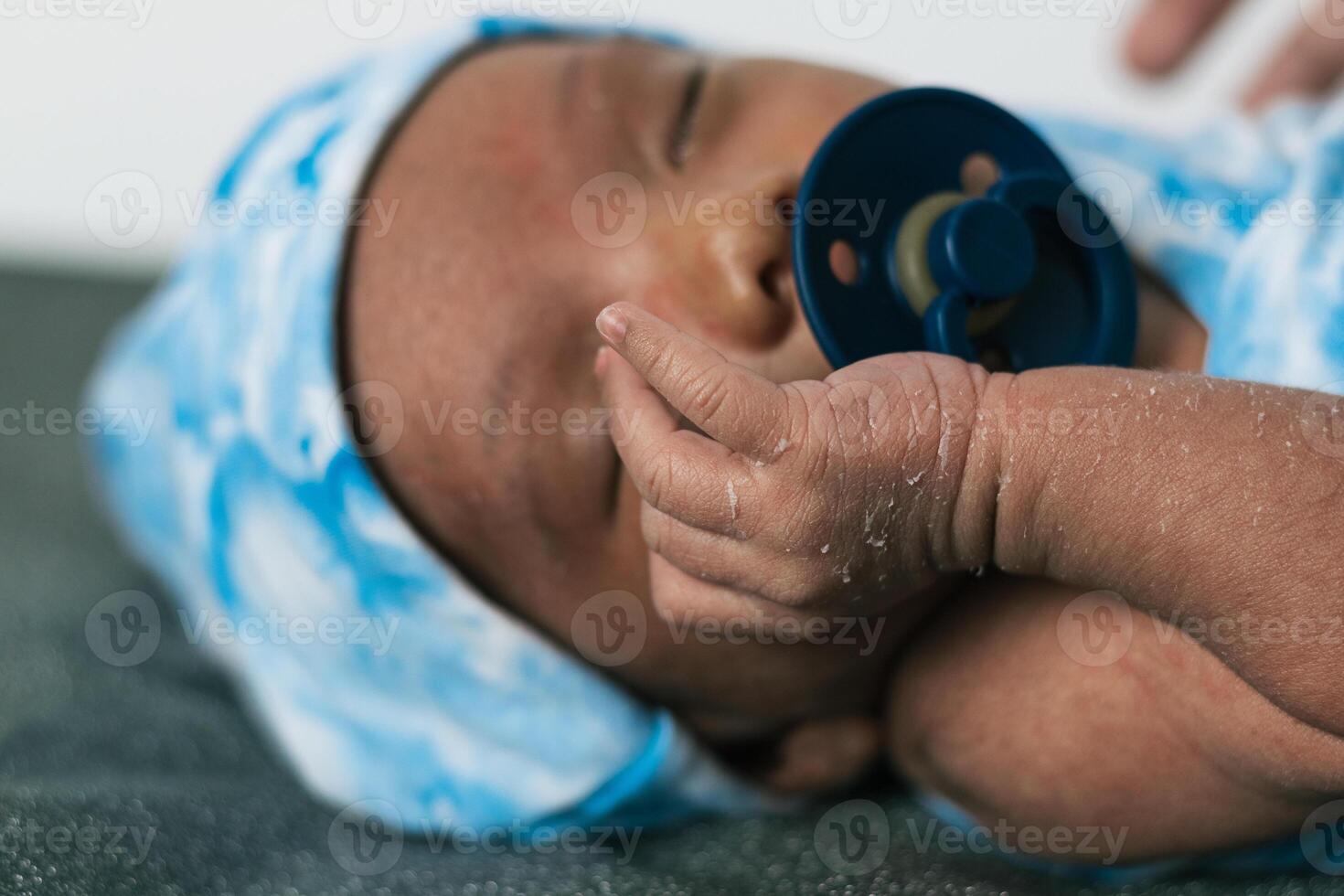Newborn baby wrapped on soft blanket with pacifier photo