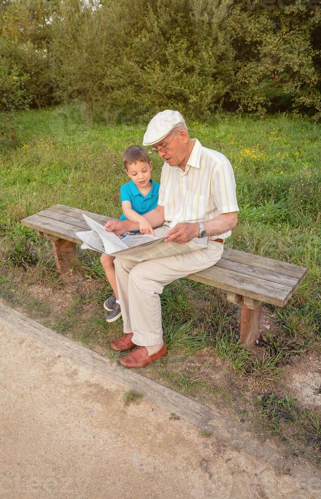 A man and a boy sitting on a bench photo