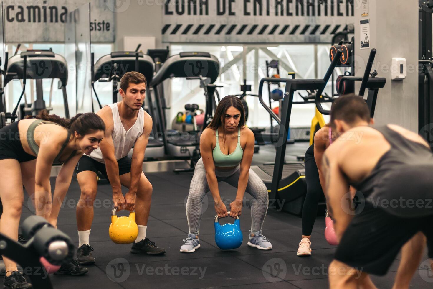 A group of people in a gym doing kettlebell exercises photo