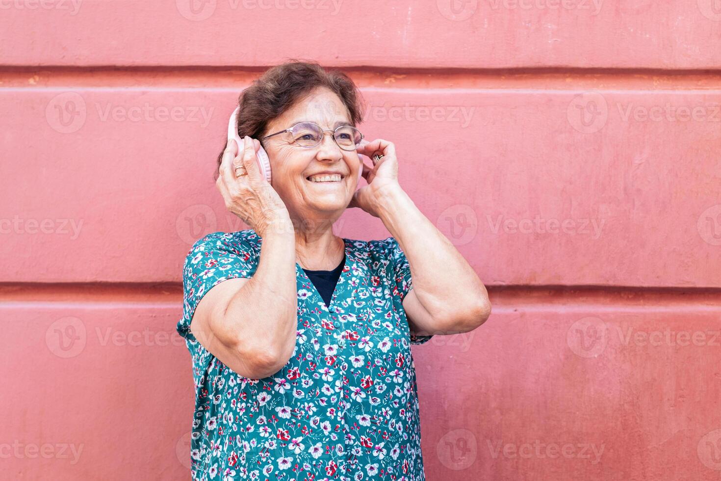 Senior woman in colorful clothes and modern headphones photo
