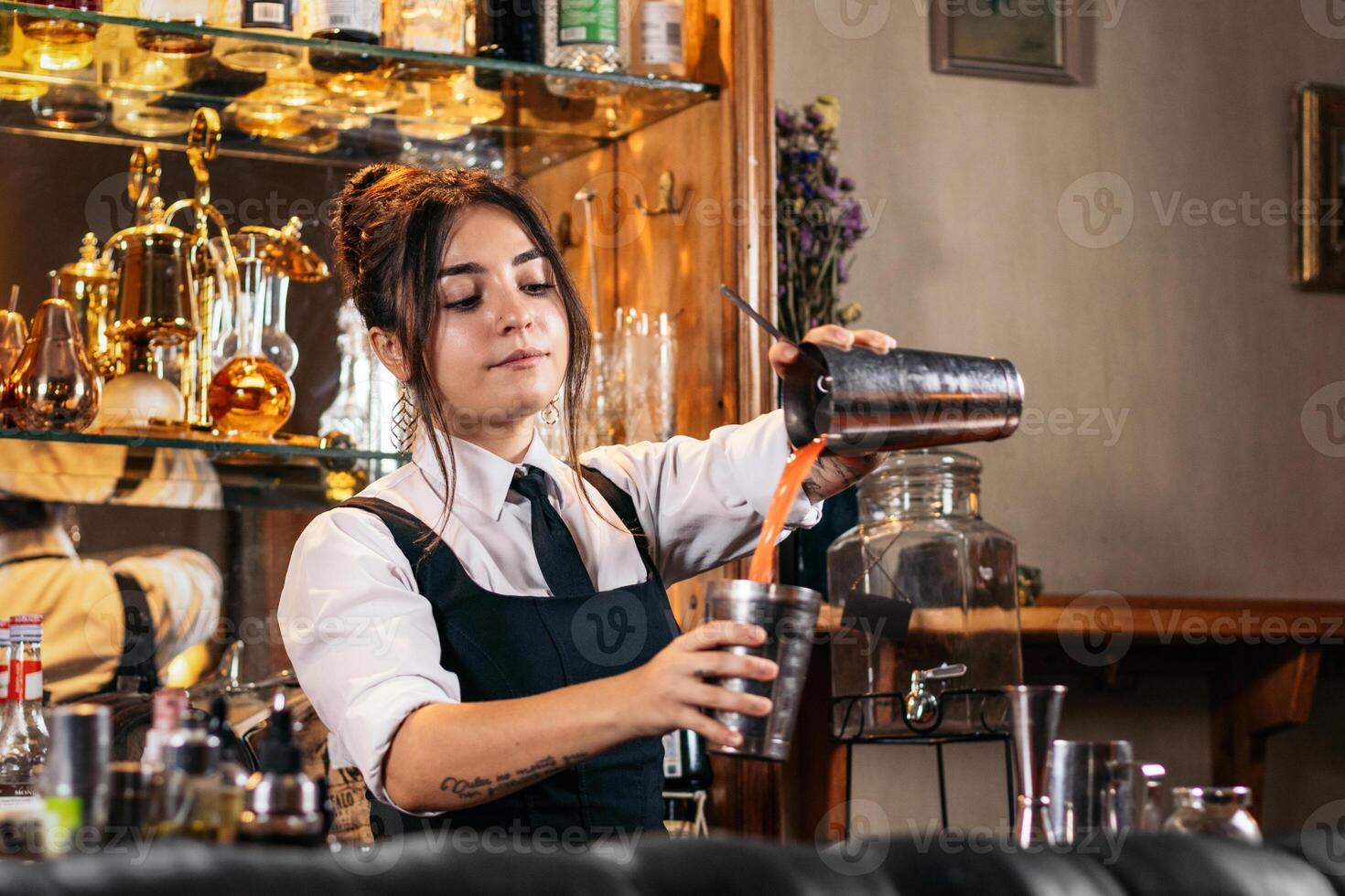 Female bartender preparing a cocktail in a traditional cocktail bar photo