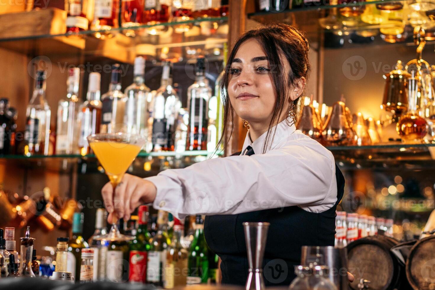 Young female bartender offering a drink photo