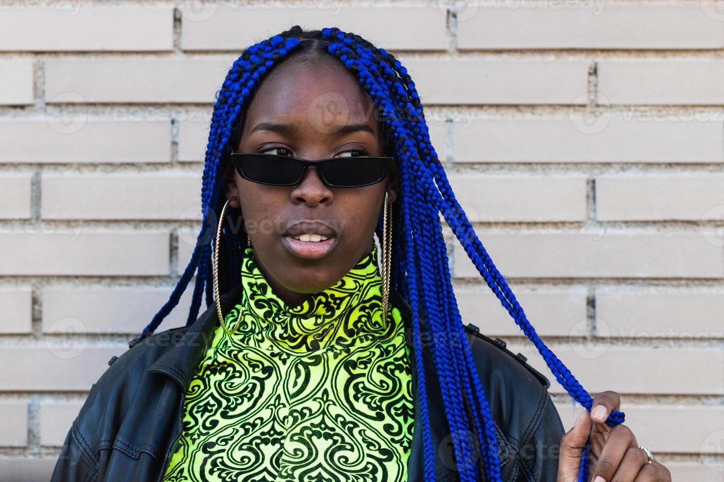 Determined black woman in trendy clothes in city photo