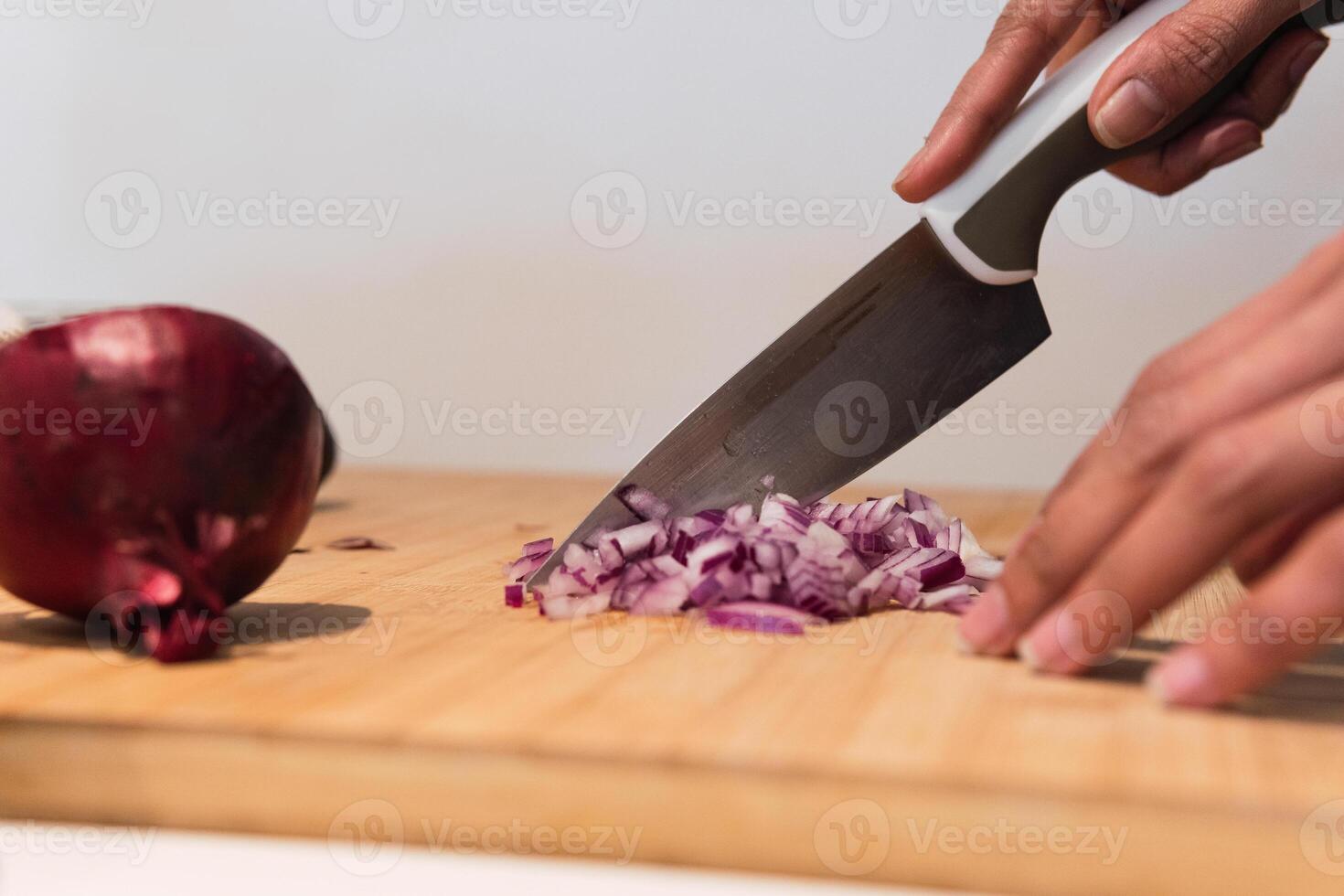 Crop woman cutting onion in kitchen photo