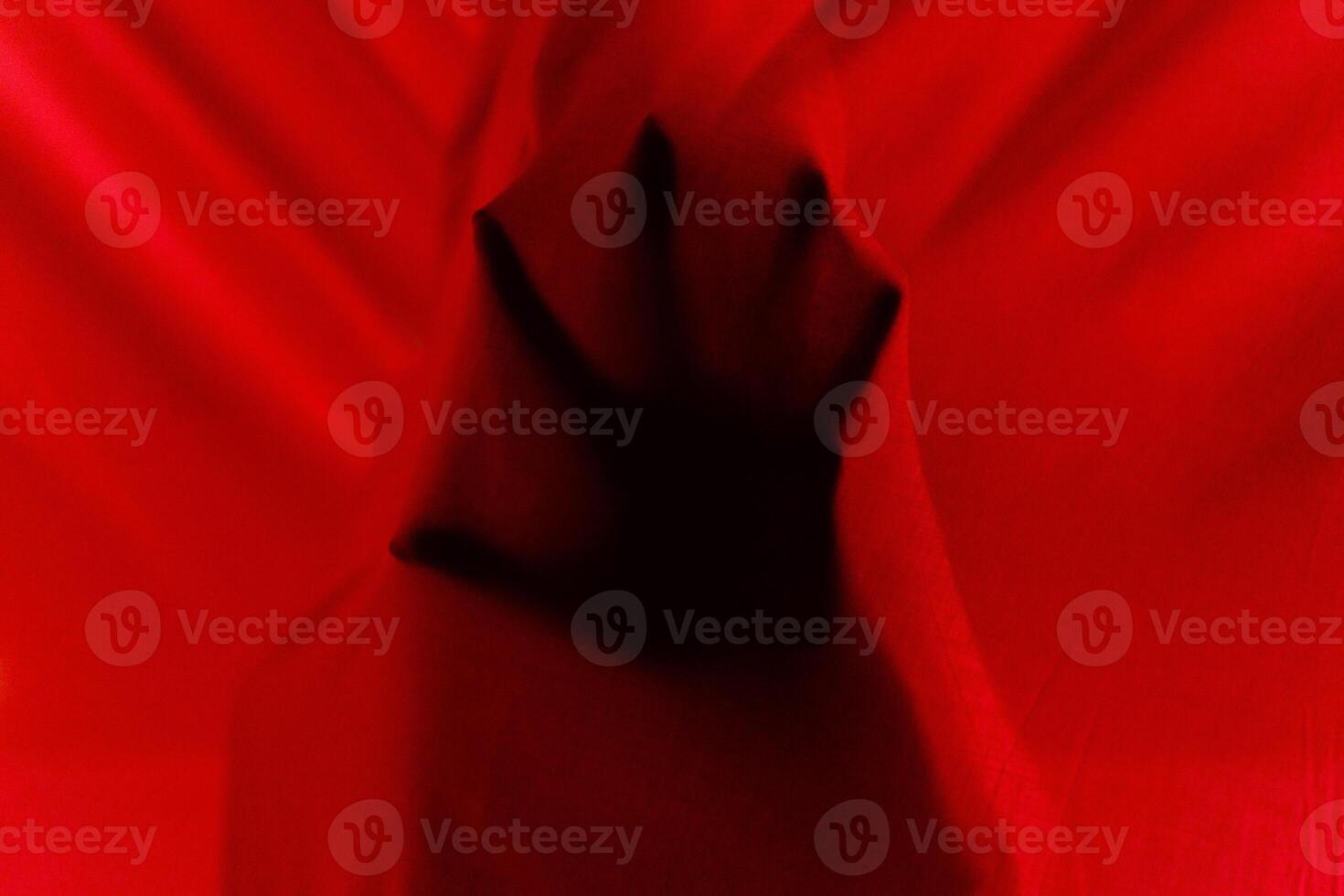 Faceless person hiding behind curtains at night time photo