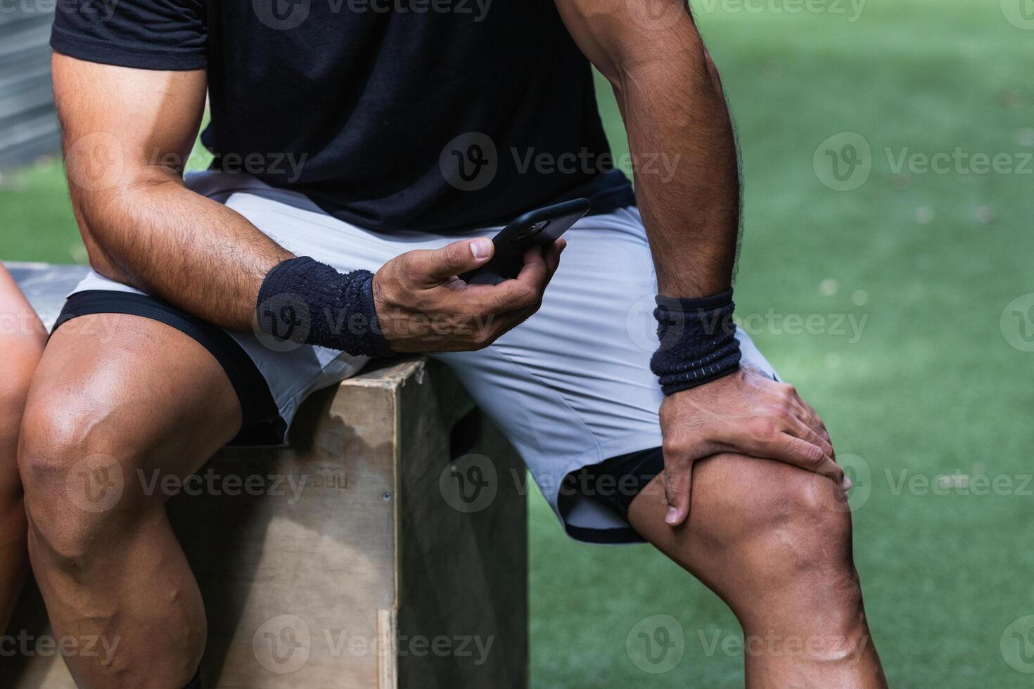 Anonymous fit ethnic man browsing smartphone during training photo