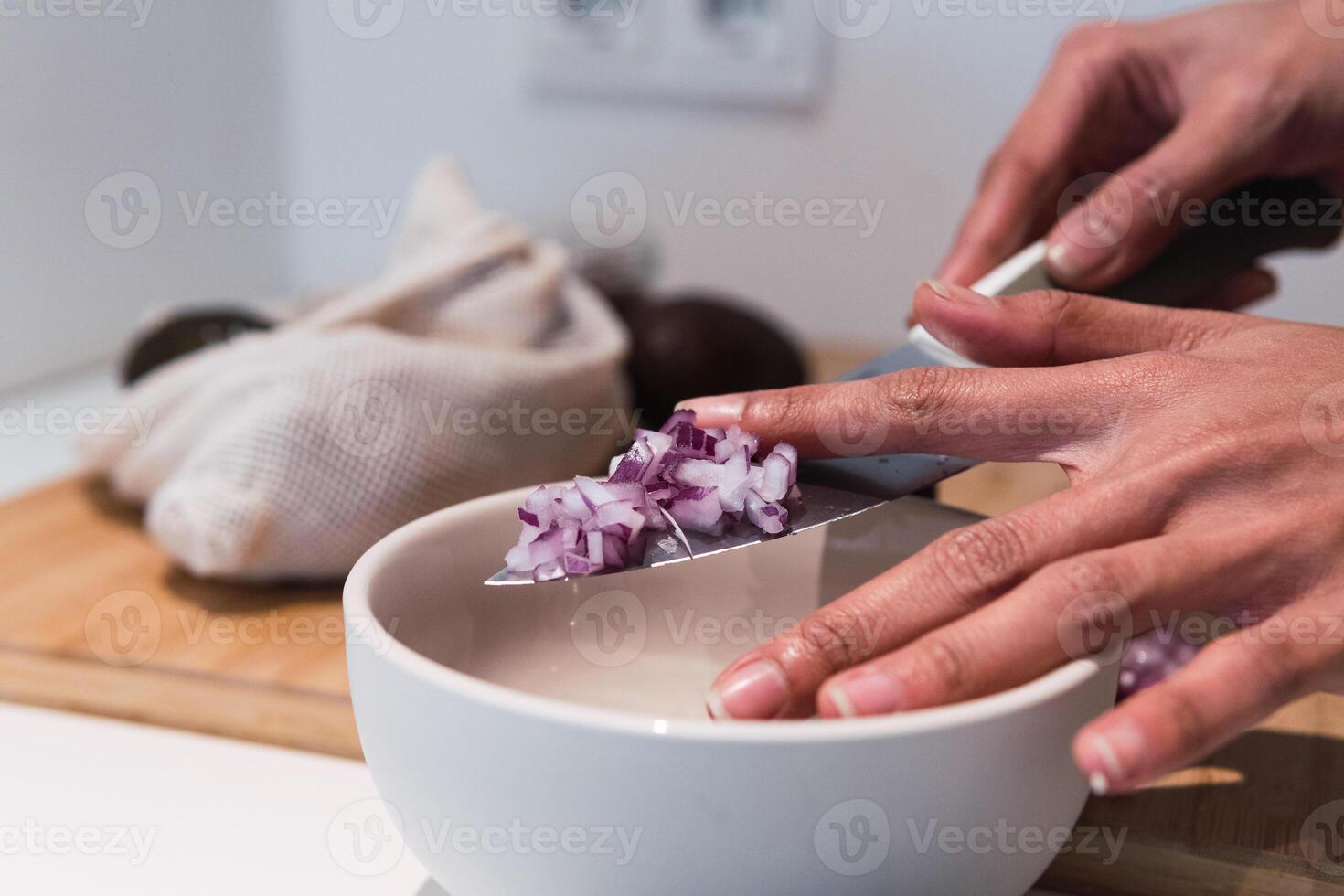 Crop woman cutting onion in kitchen photo