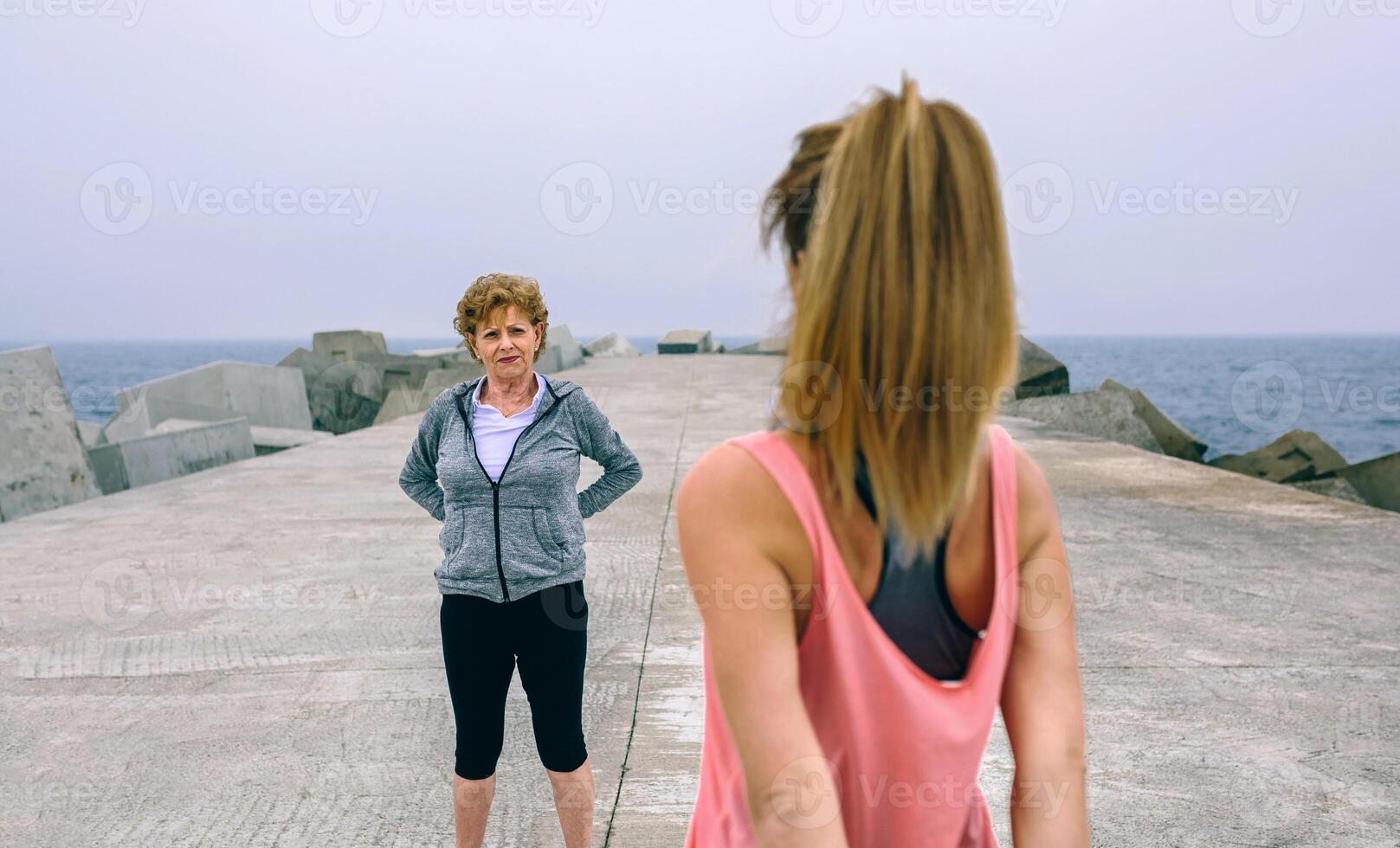 Woman stretching with senior woman photo