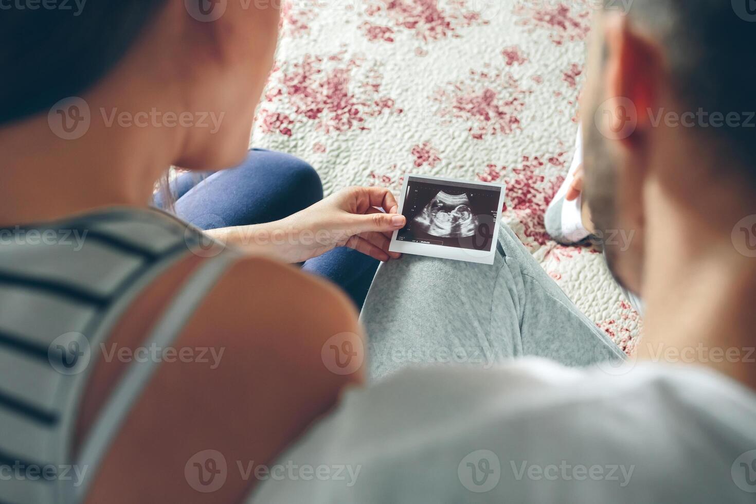 Couple looking at ultrasound of their baby photo