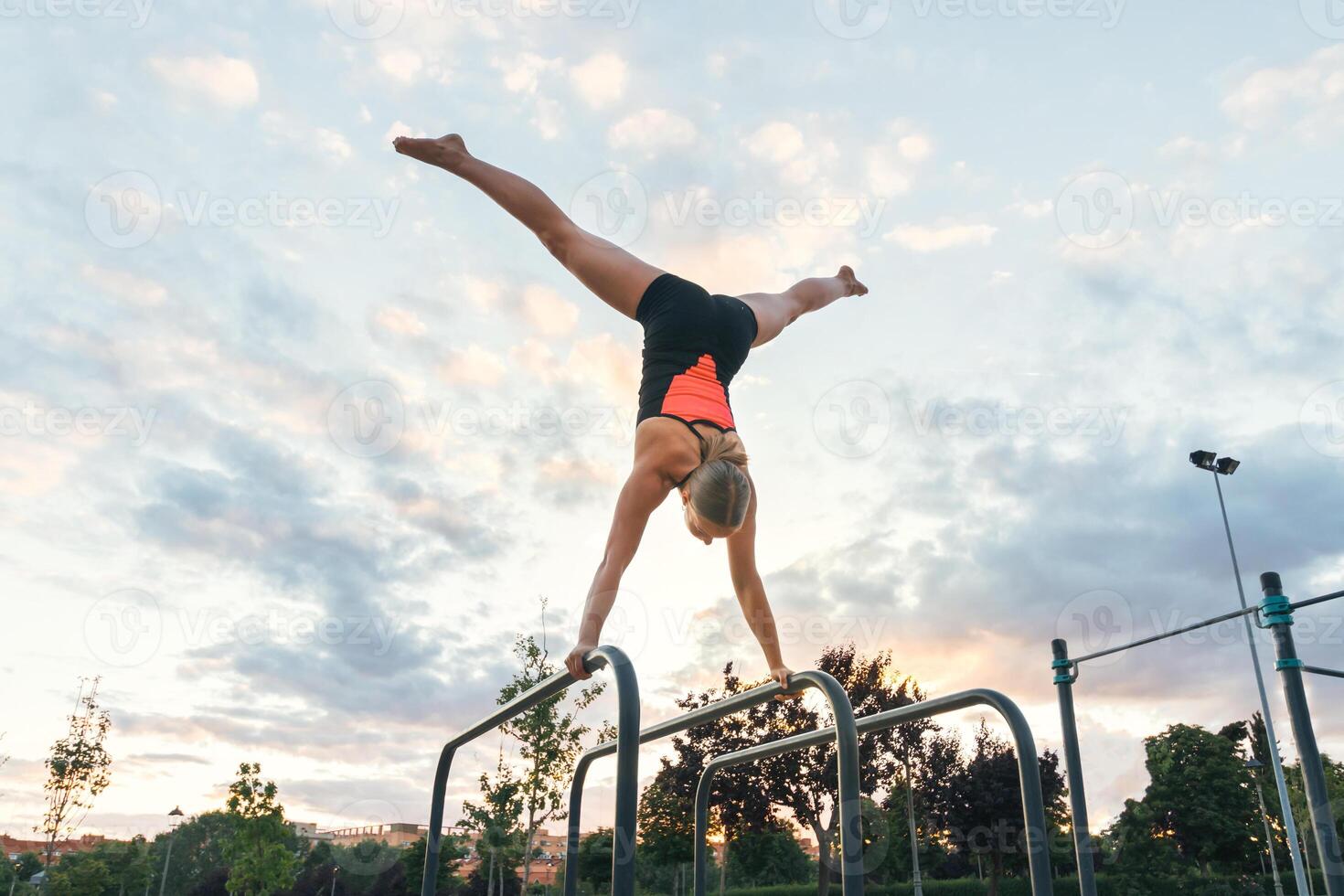woman athlete doing handstand on parallel bars photo