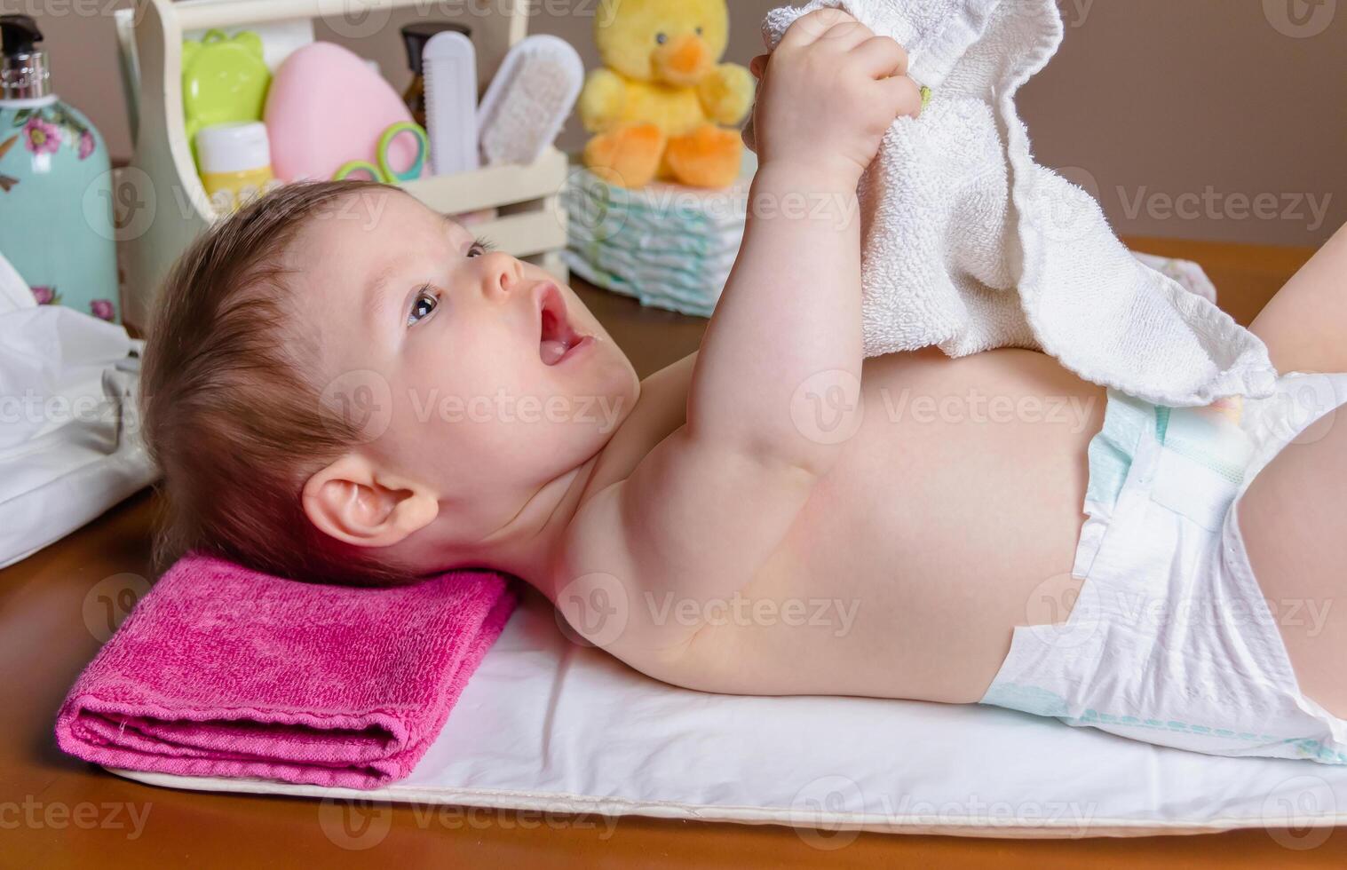 Baby lying playing with a small towel photo