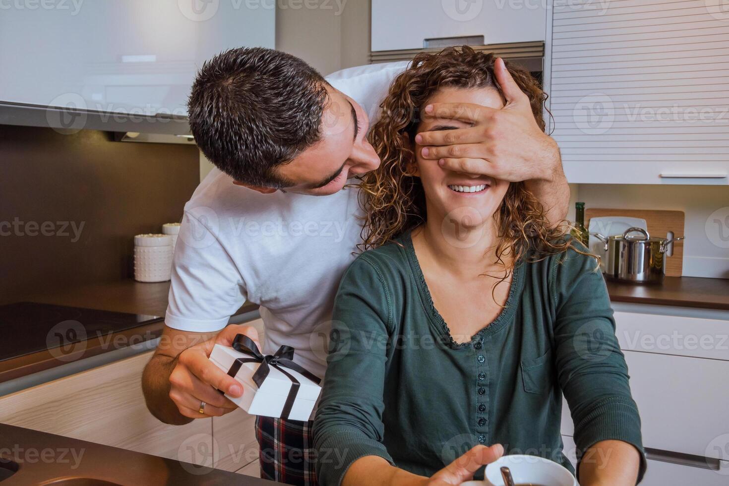 Man with gift box closing his girlfriend eyes for a surprise photo