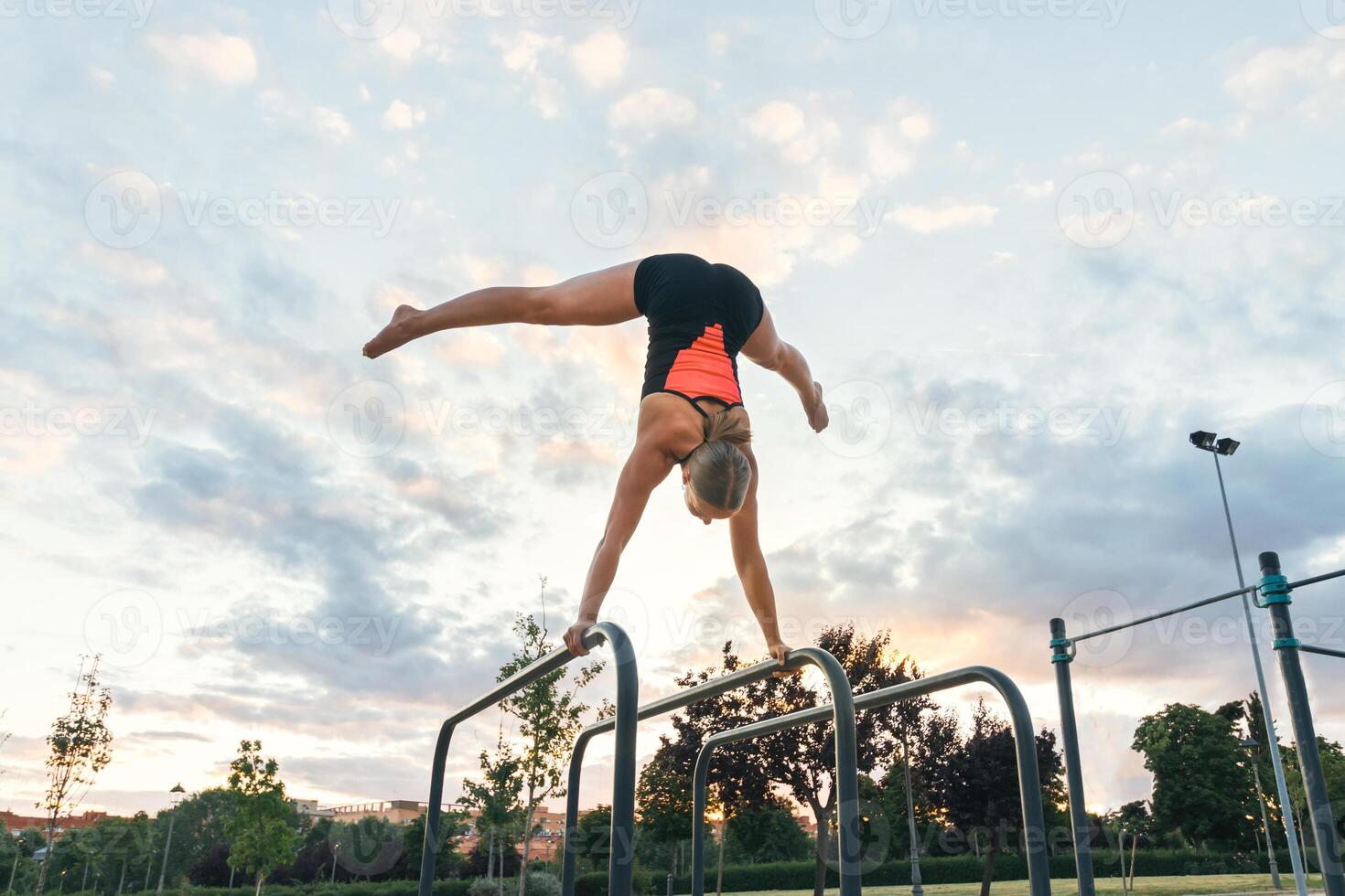 woman athlete doing handstand on parallel bars photo