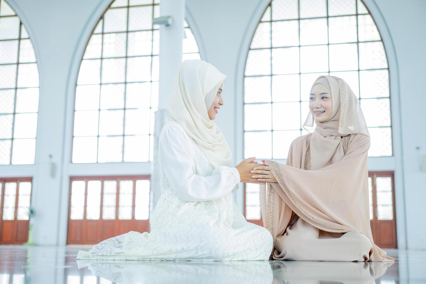 Portrait hands of two muslim women greet each other apologizing during the ramadan Eid holiday, photo