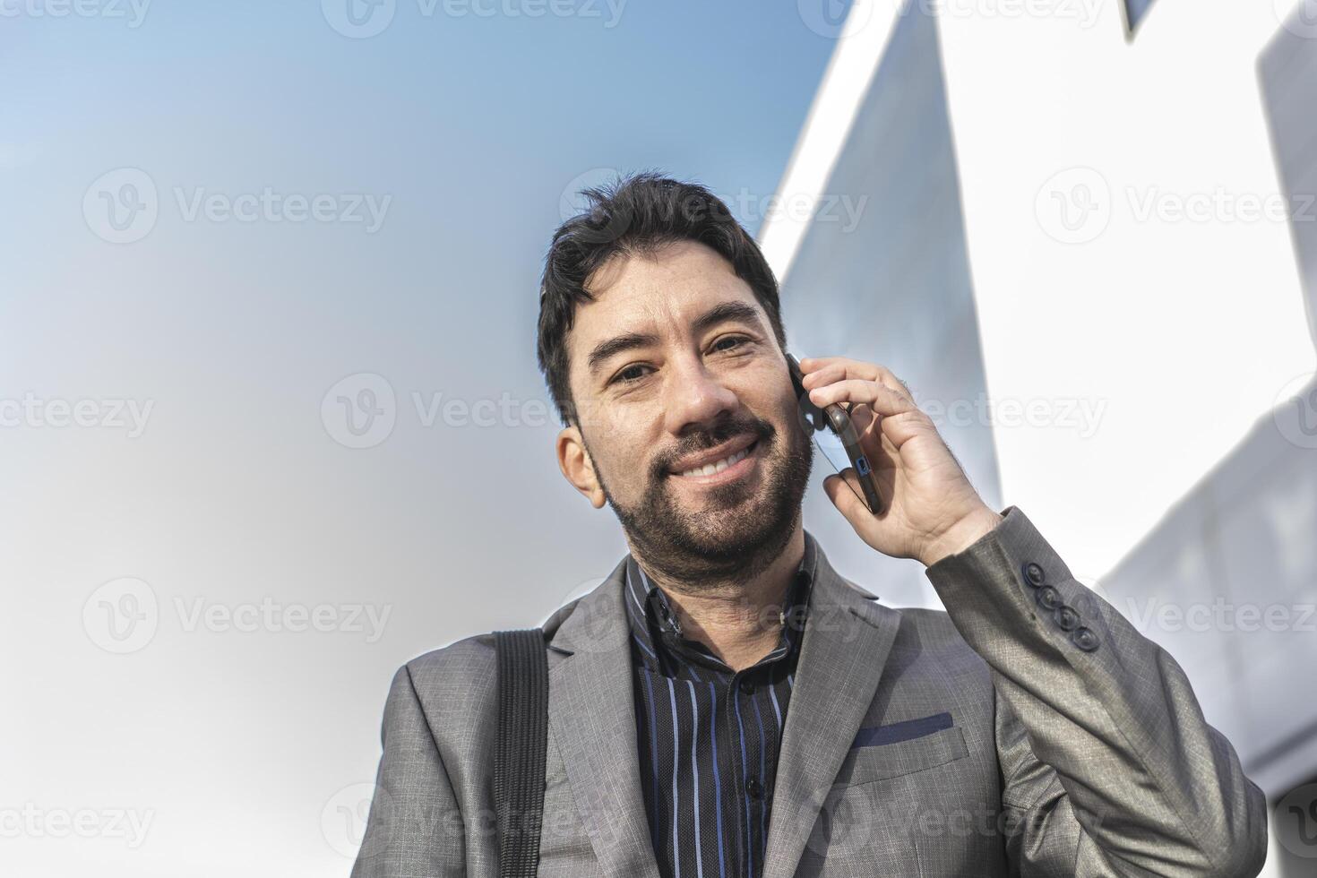 A man in a suit is talking on a cell phone photo
