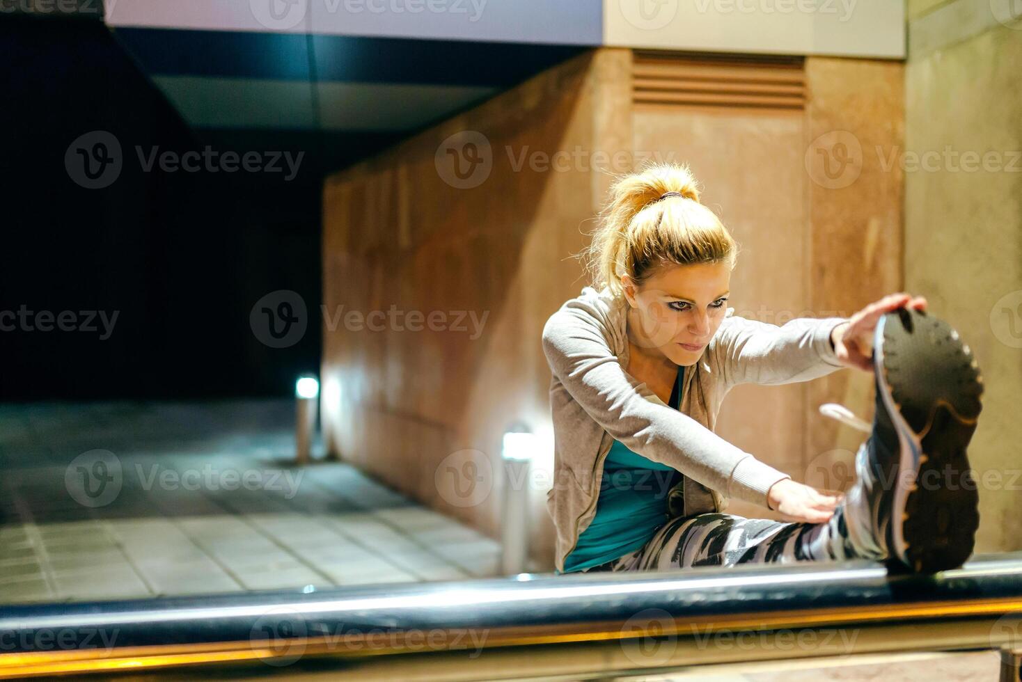 A woman is stretching on a railing photo