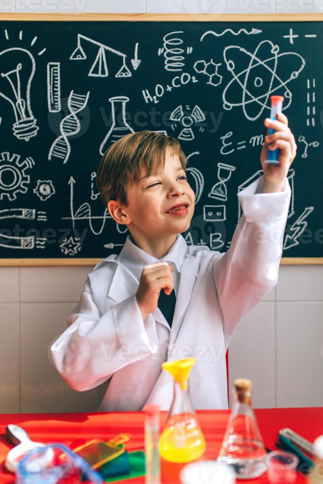 A boy in a lab coat is holding a test tube photo