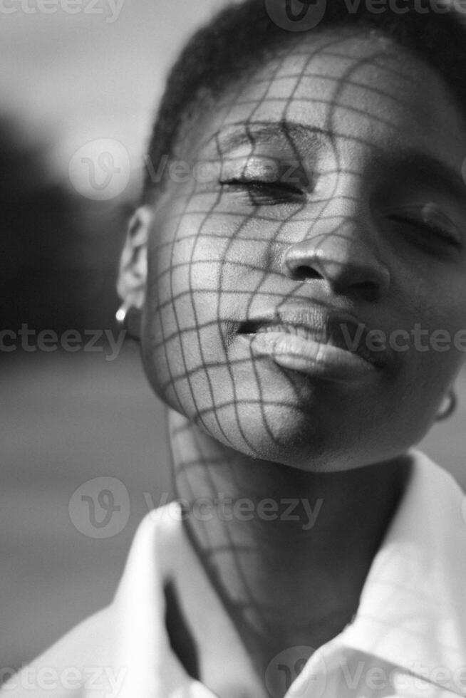 A black and white photo of a woman with a net over her face