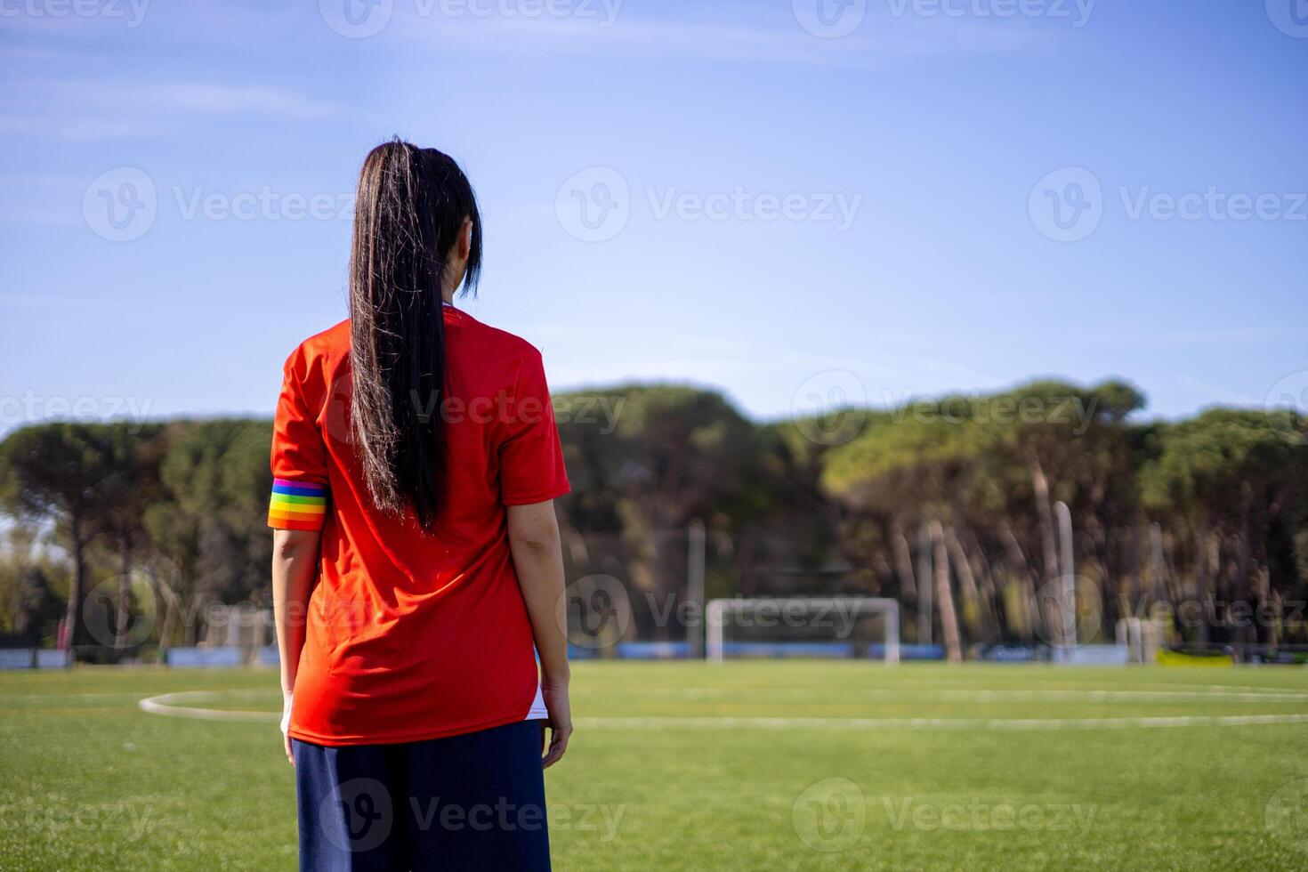 A woman in a red shirt standing on a soccer field photo
