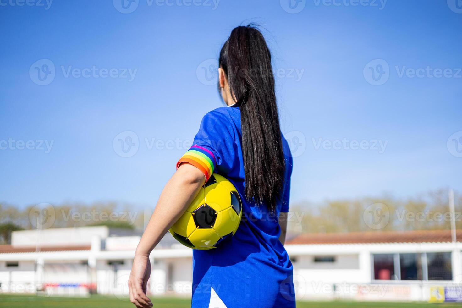 A woman with long hair holding a soccer ball photo