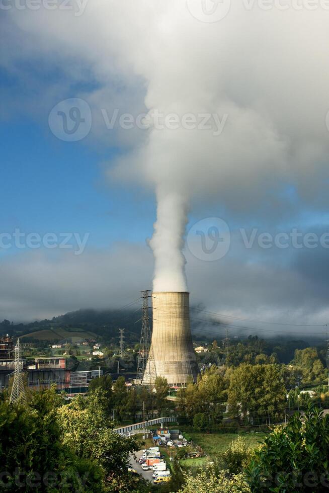 A cloud of smoke coming out of a power plant photo