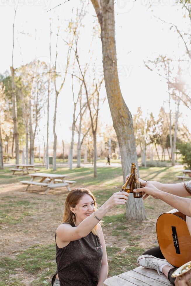 Two women toasting with beer in a park photo