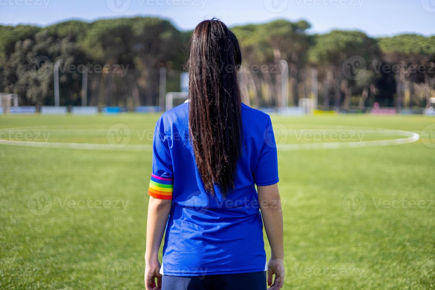 A woman in a blue shirt standing on a soccer field photo