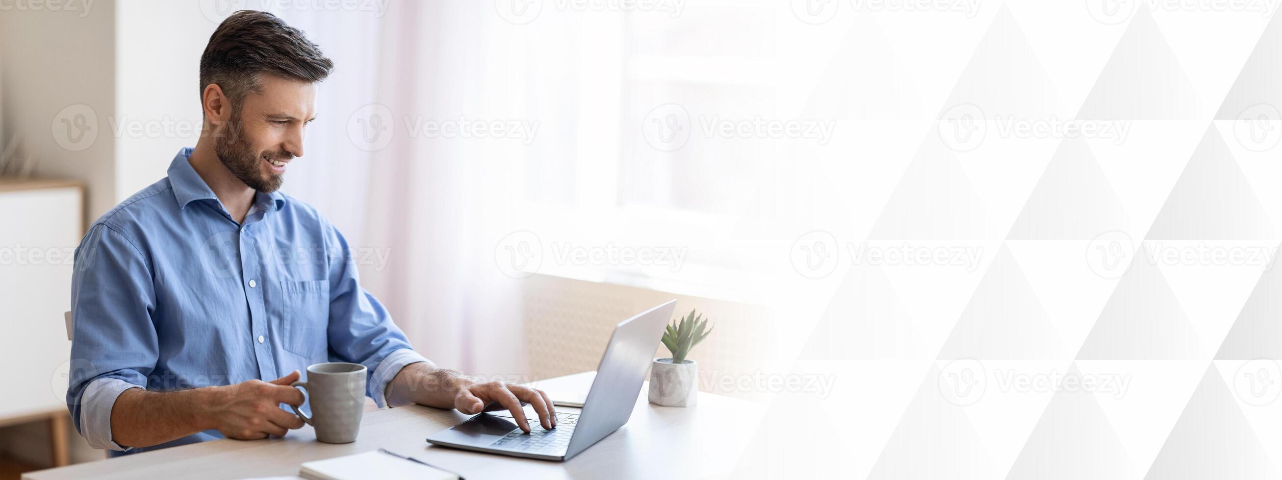 Home Office. Smiling Freelancer Man Checking Emails On Laptop And Drinking Coffee, Enjoying Working Remotely, Copy Space photo