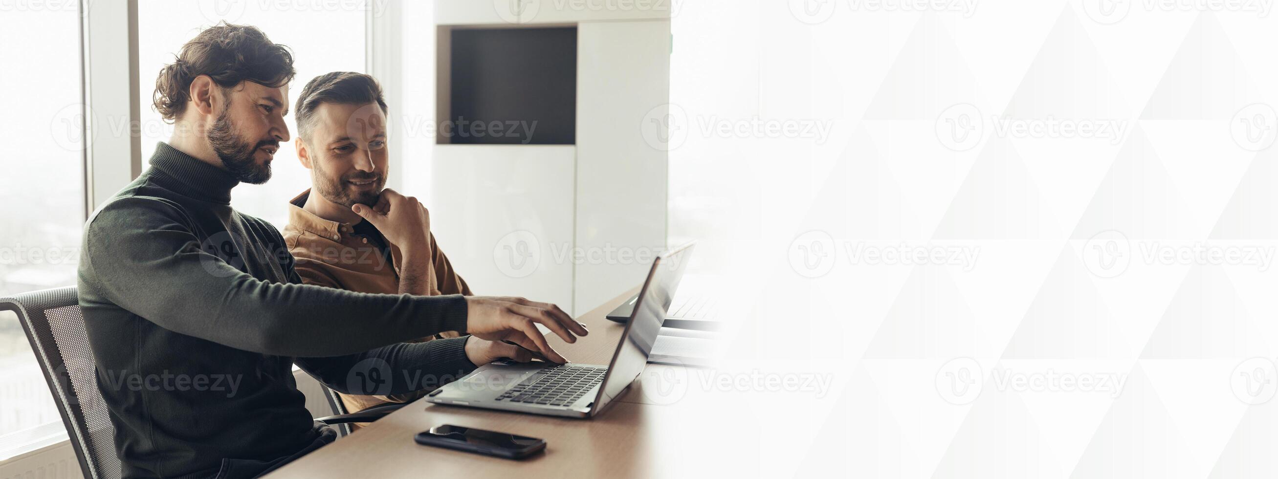 Two men colleagues working on startup project together, discussing ideas, using laptop computer at company office, copy space. Successful coworking and collaboration concept photo