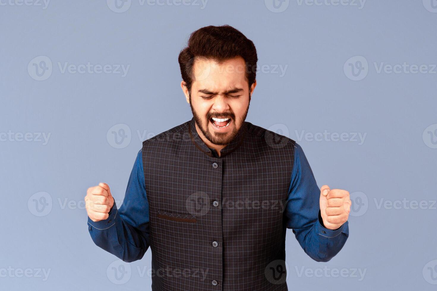 Furious Indian man clenching fists in anger and screaming on lilac background, panorama photo