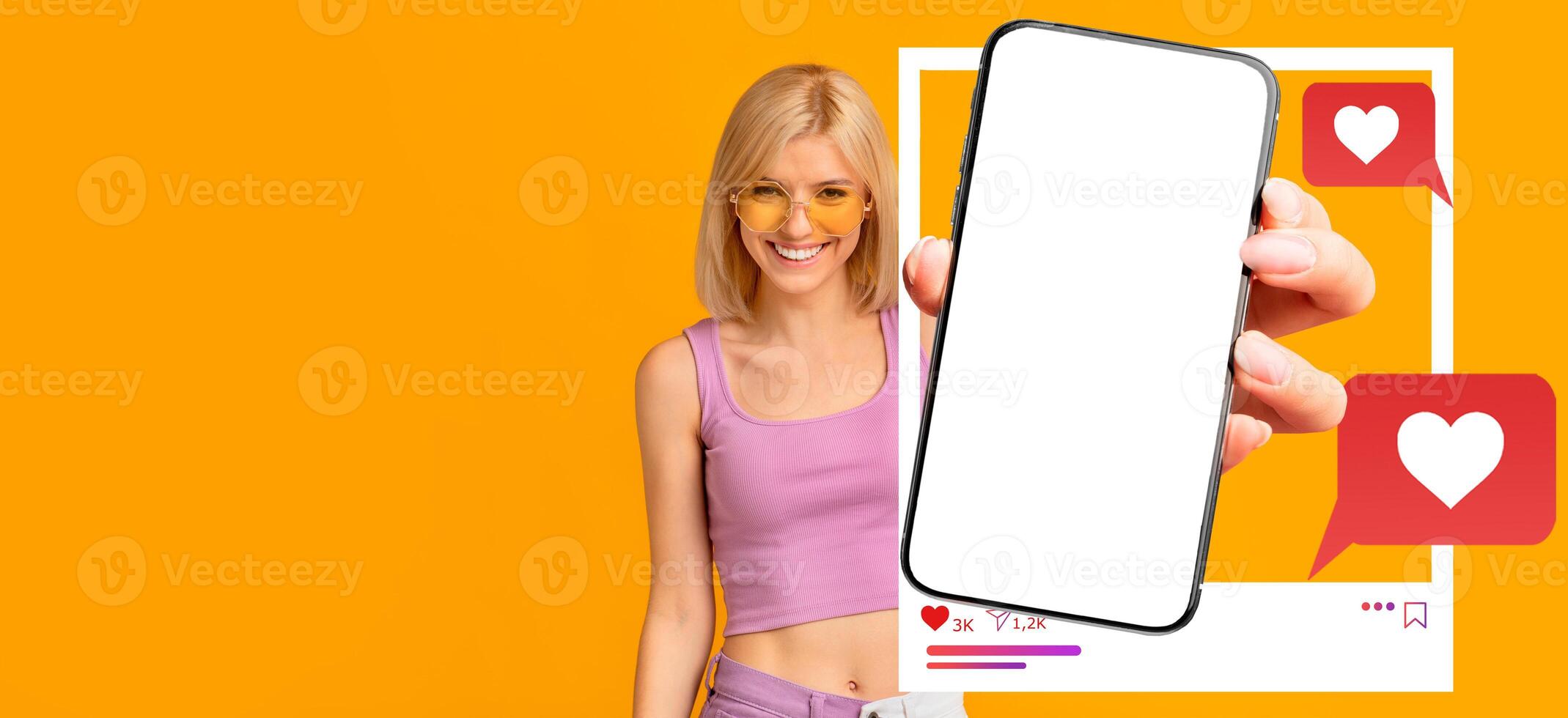 A cheerful influencer holds a blank smartphone, ready for social media interactions. Bright background with heart symbols and chat bubbles emphasizes online communication and engagement. photo