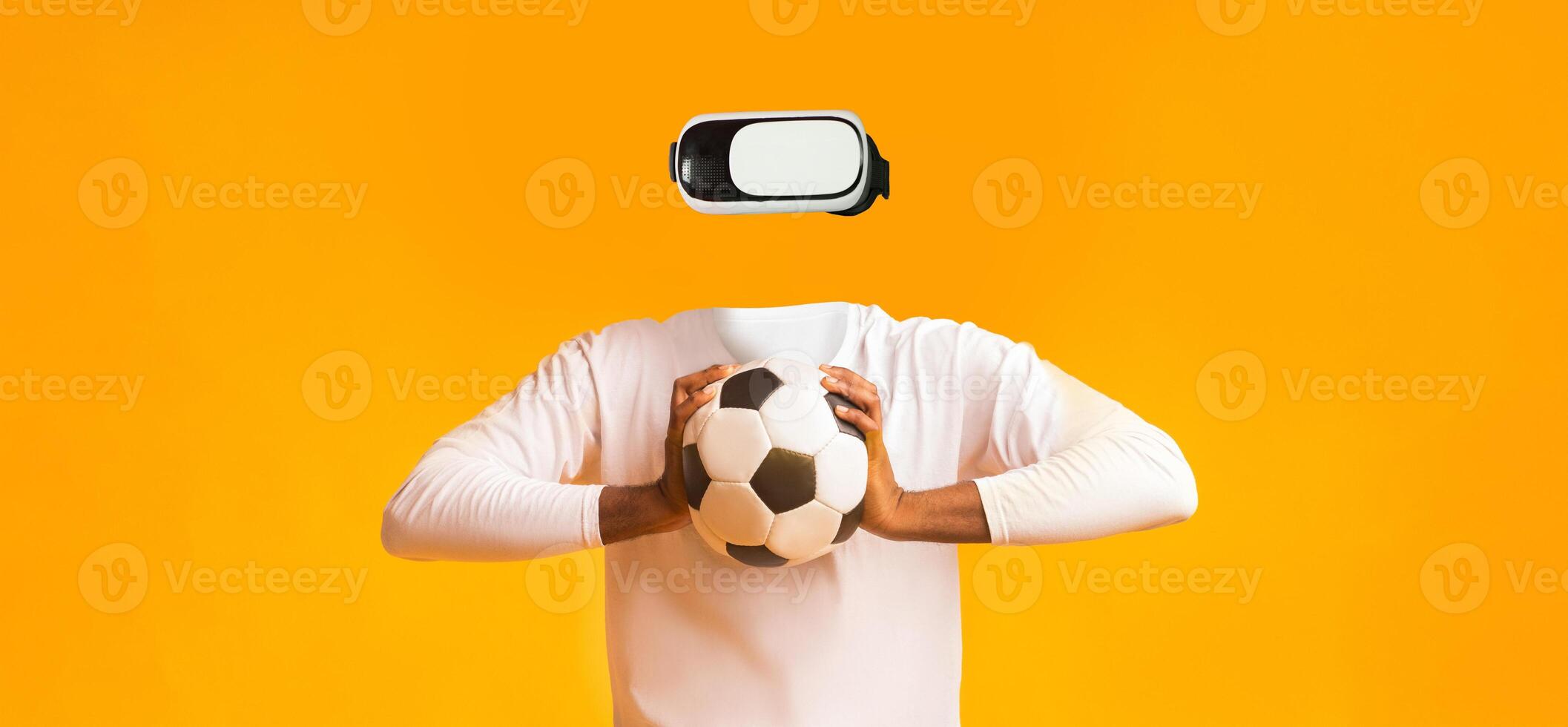 A person enjoys a virtual reality experience while holding a soccer ball. The individual has no visible head, emphasizing the focus on technology and sports. photo