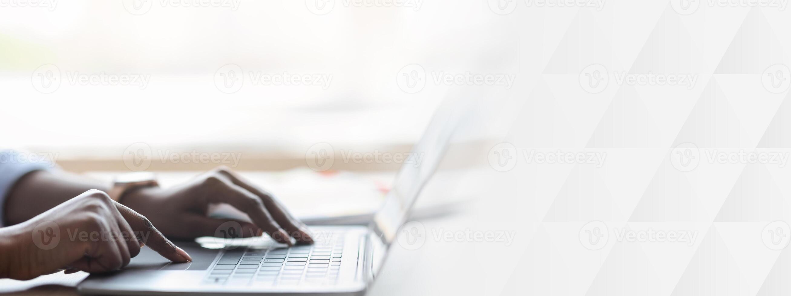 Closeup of unrecognizable black woman working on laptop, typing on computer keyboard while working in office, side view, cropped image photo