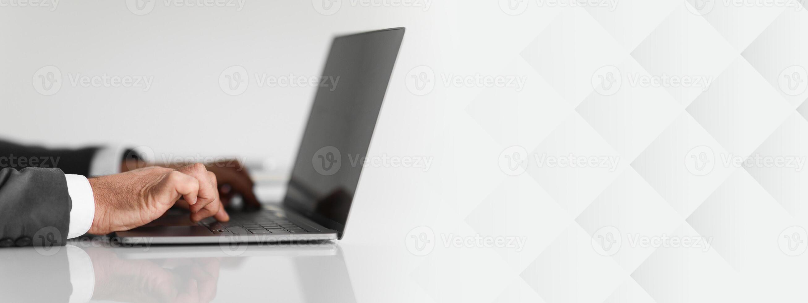 Close-up of caucasian businessman's hands typing on a laptop keyboard, showcasing details of his blue suit sleeve and professional work environment, cropped. Work, business photo