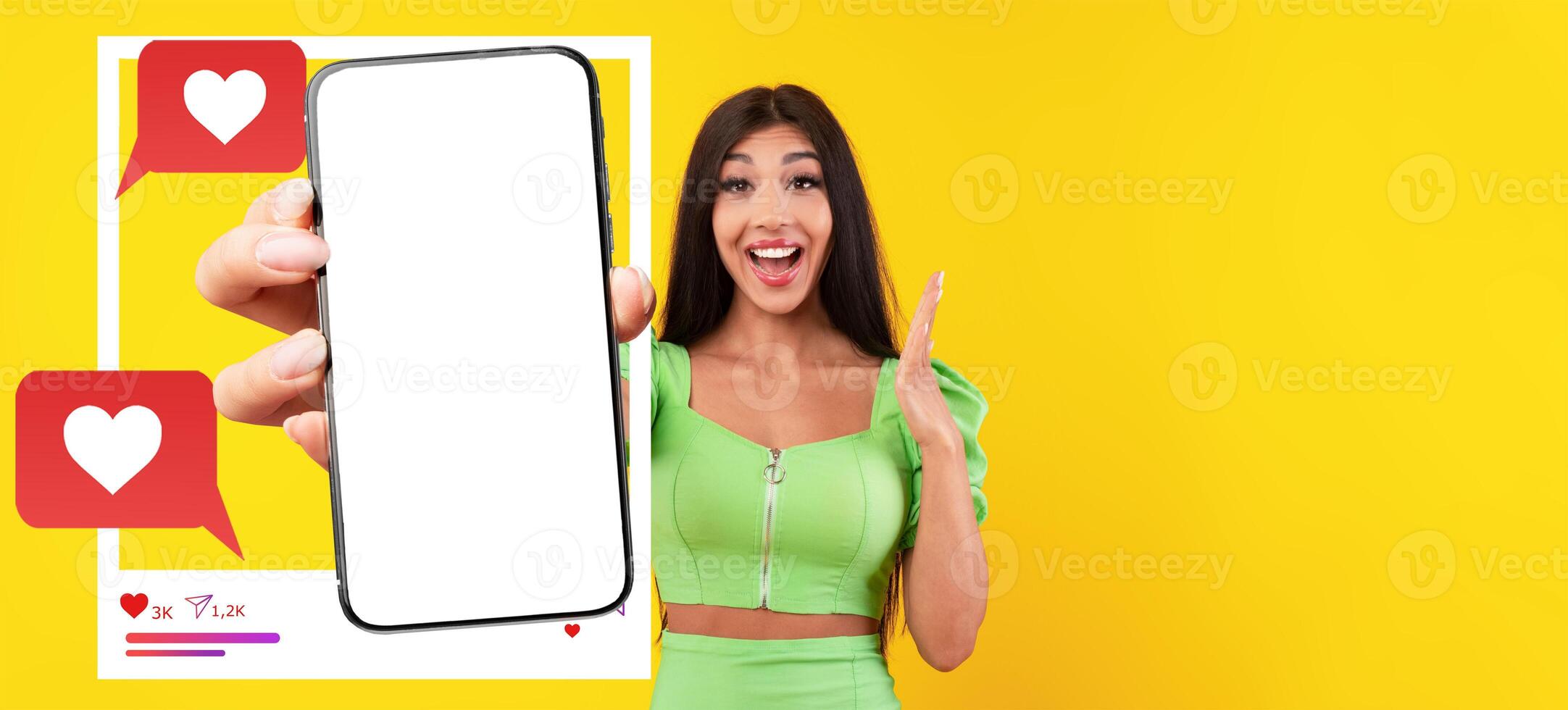 An influencer in a vibrant outfit happily displays a smartphone with a blank screen, inviting viewers to imagine their own app content. photo