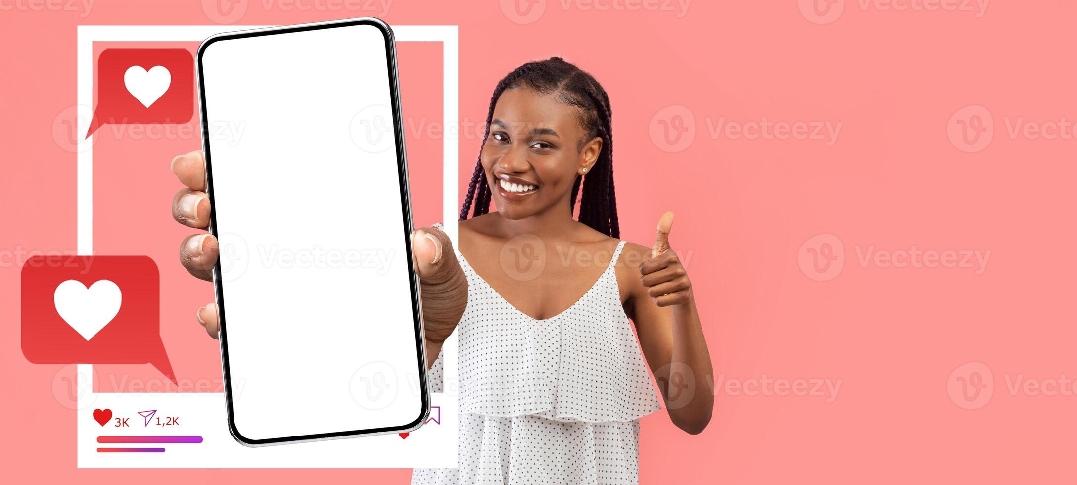 A smiling influencer holds a blank smartphone, ready to engage with followers. The background features colorful chat bubbles with hearts, emphasizing social media interaction. photo