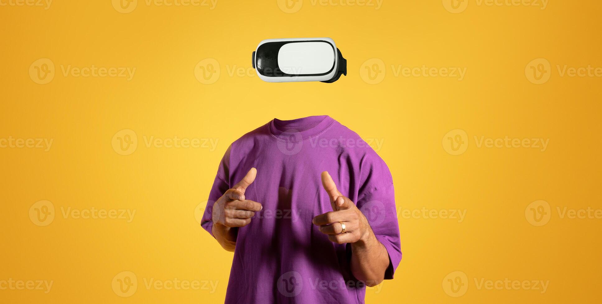 A person wearing virtual reality goggles engages in an immersive experience, showcasing the technology's impact. The bright yellow background enhances the focus on modern gadgets. photo
