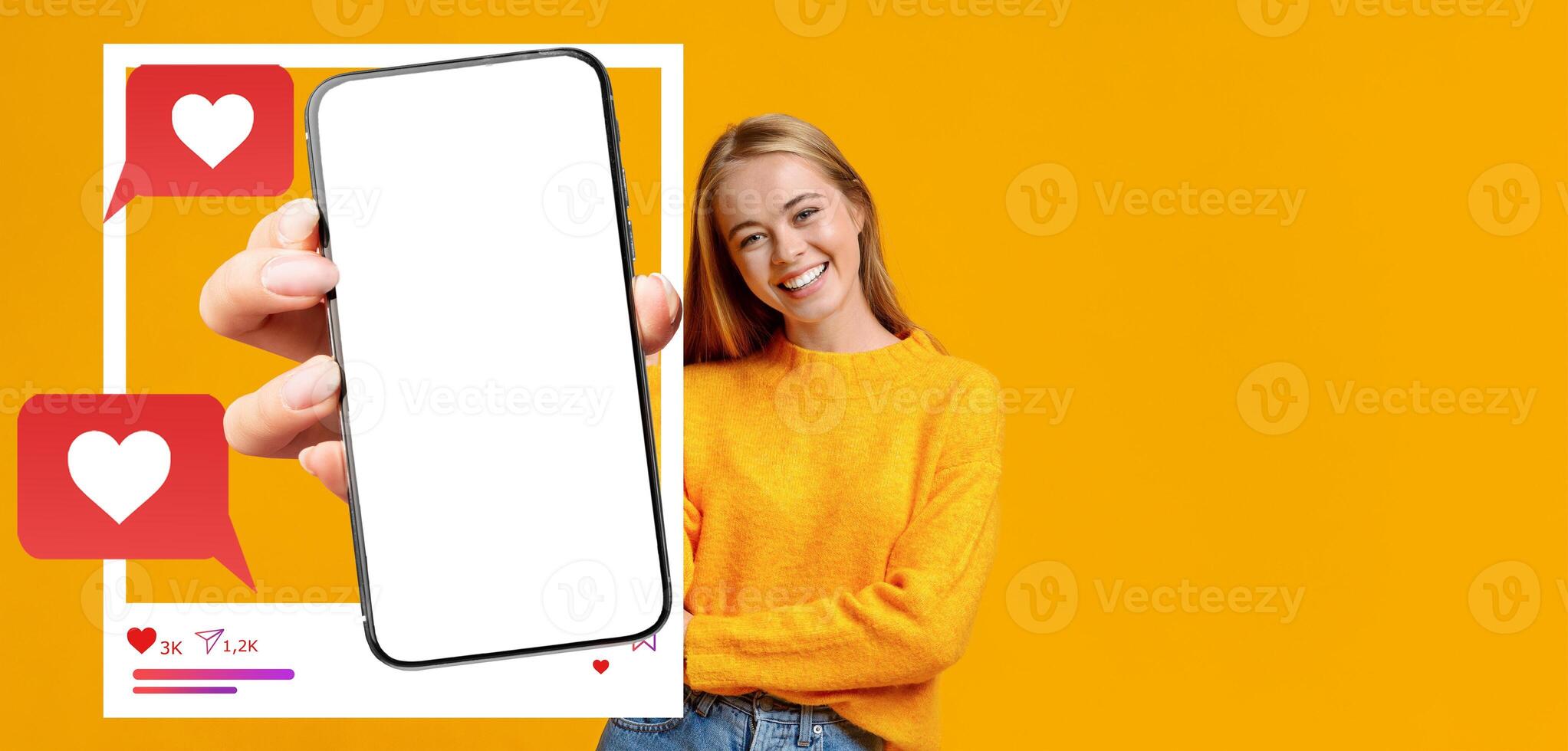 An influencer in a yellow sweater smiles while holding a smartphone. The blank screen is ready for showcasing applications, messages, and social media interactions, emphasizing online communication. photo