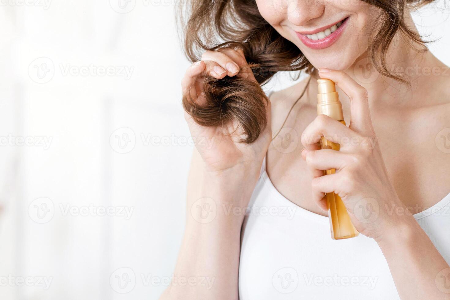 Pretty girl applying hair oil to prevent split ends, hair care at home, copy space photo