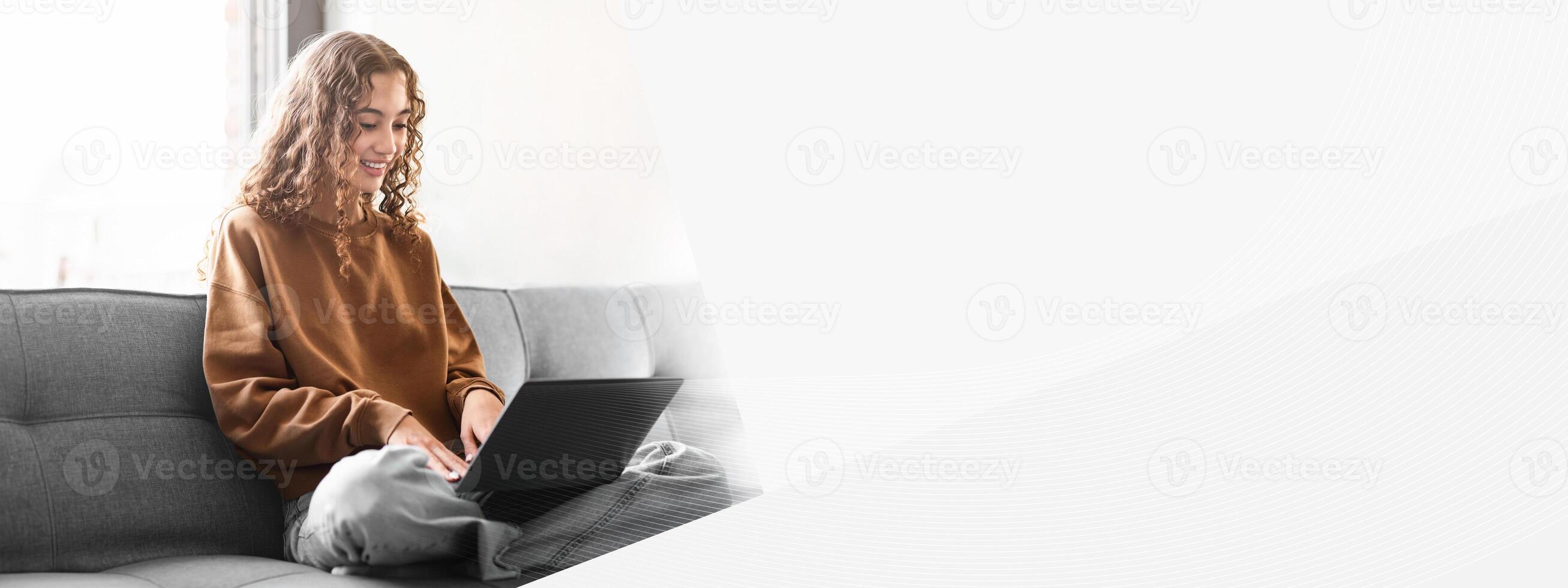 E-Learning Offer. Smiling Young Student Lady Using Laptop Learning Online, Typing And Websurfing For College Homework, Sitting On Sofa At Home. Modern Distance Education Concept photo