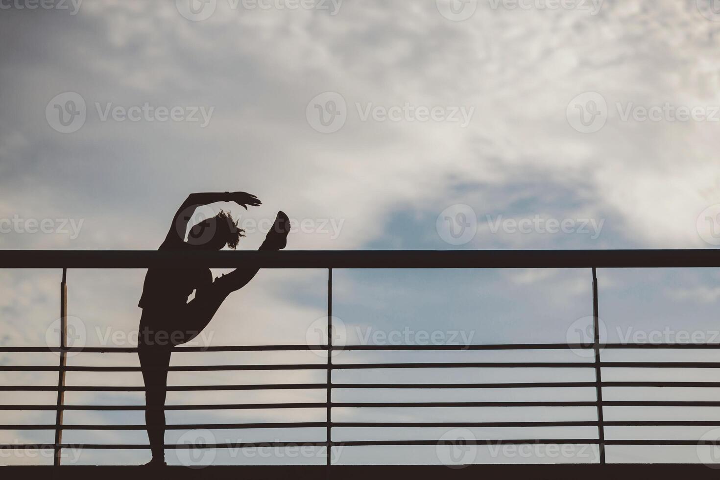 Stretching for muscles before marathon. Silhouette of slender muscular african american girl, does exercises for legs at stadium, copy space photo