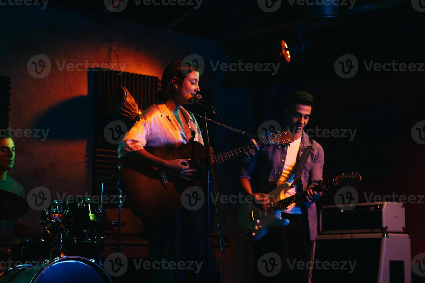Musicians In Stage With Colorful Lights Performing In A Live Concert photo