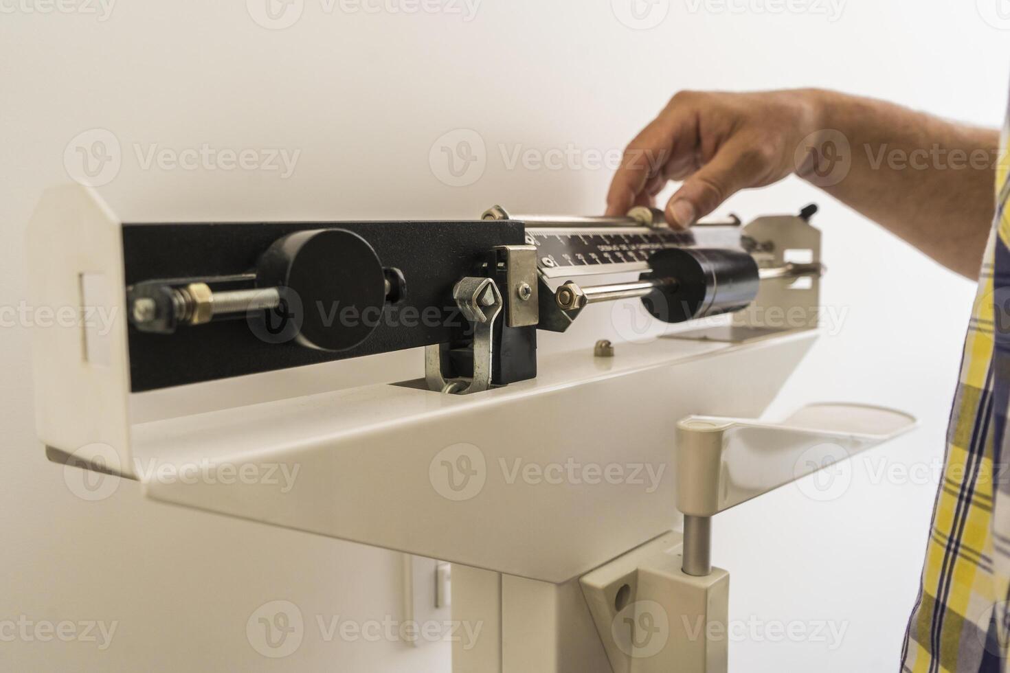 Close-up of man on weighing scale in nutritionist's office. photo